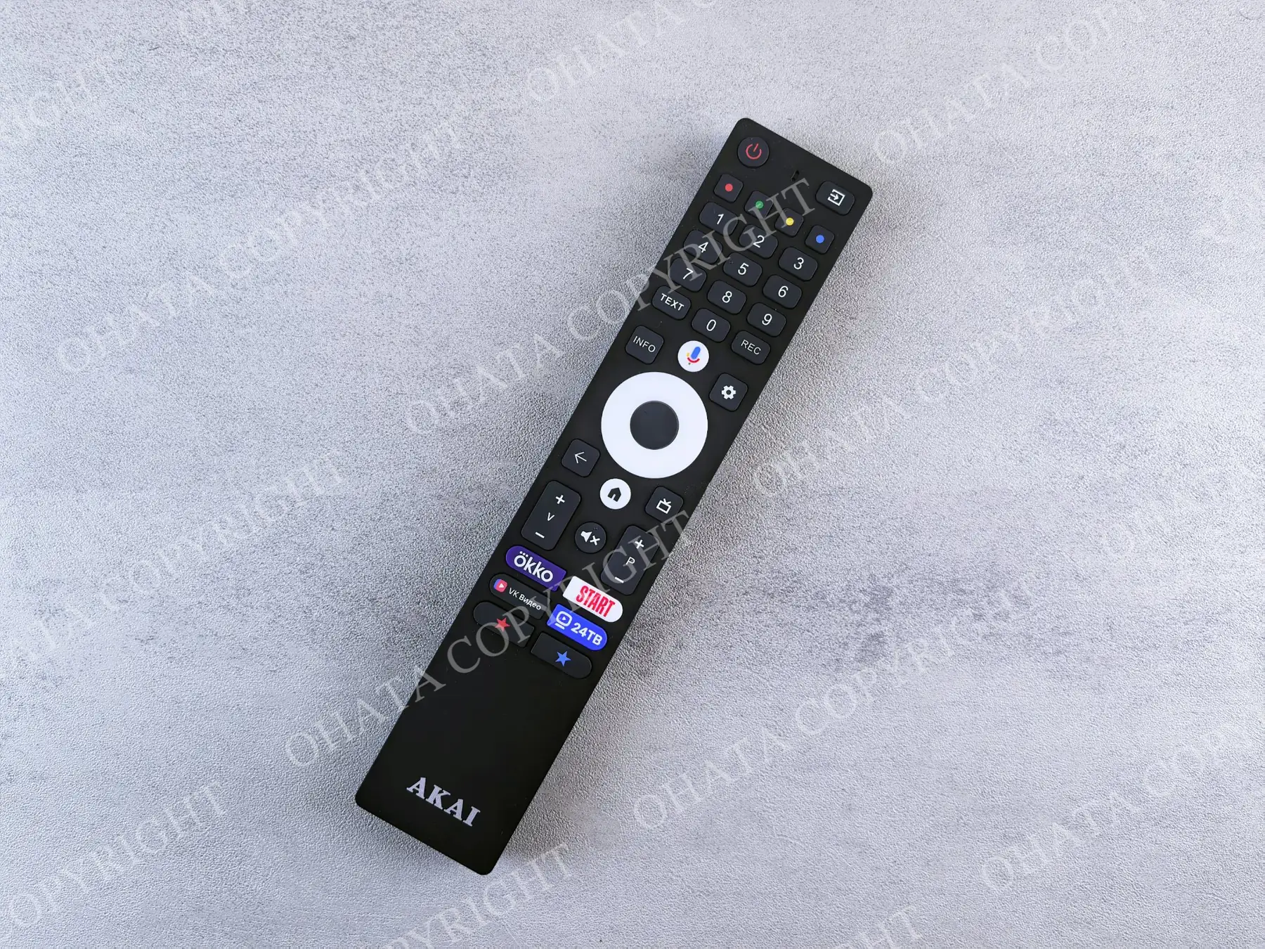 Black AKAI television remote with a numeric keypad, navigation ring, and streaming shortcut buttons.