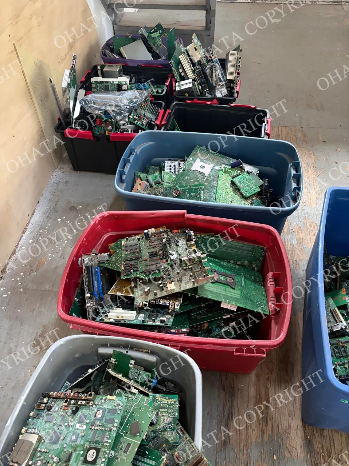 Assorted computer, industrial, and electronic circuit boards separated into several large plastic containers.