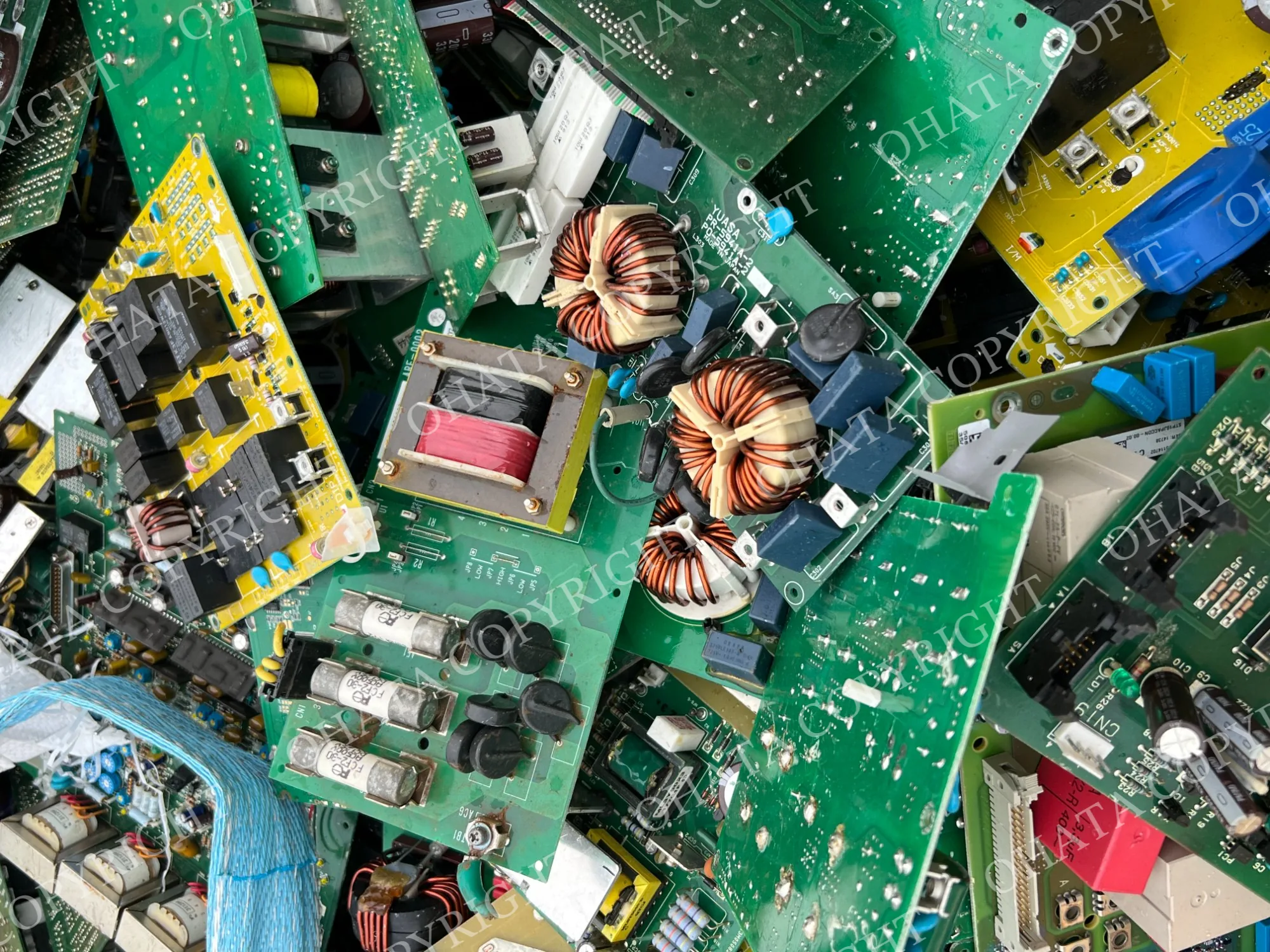Mixed green and yellow appliance circuit boards containing transformers, coils, relays, connectors, and power-control components.
