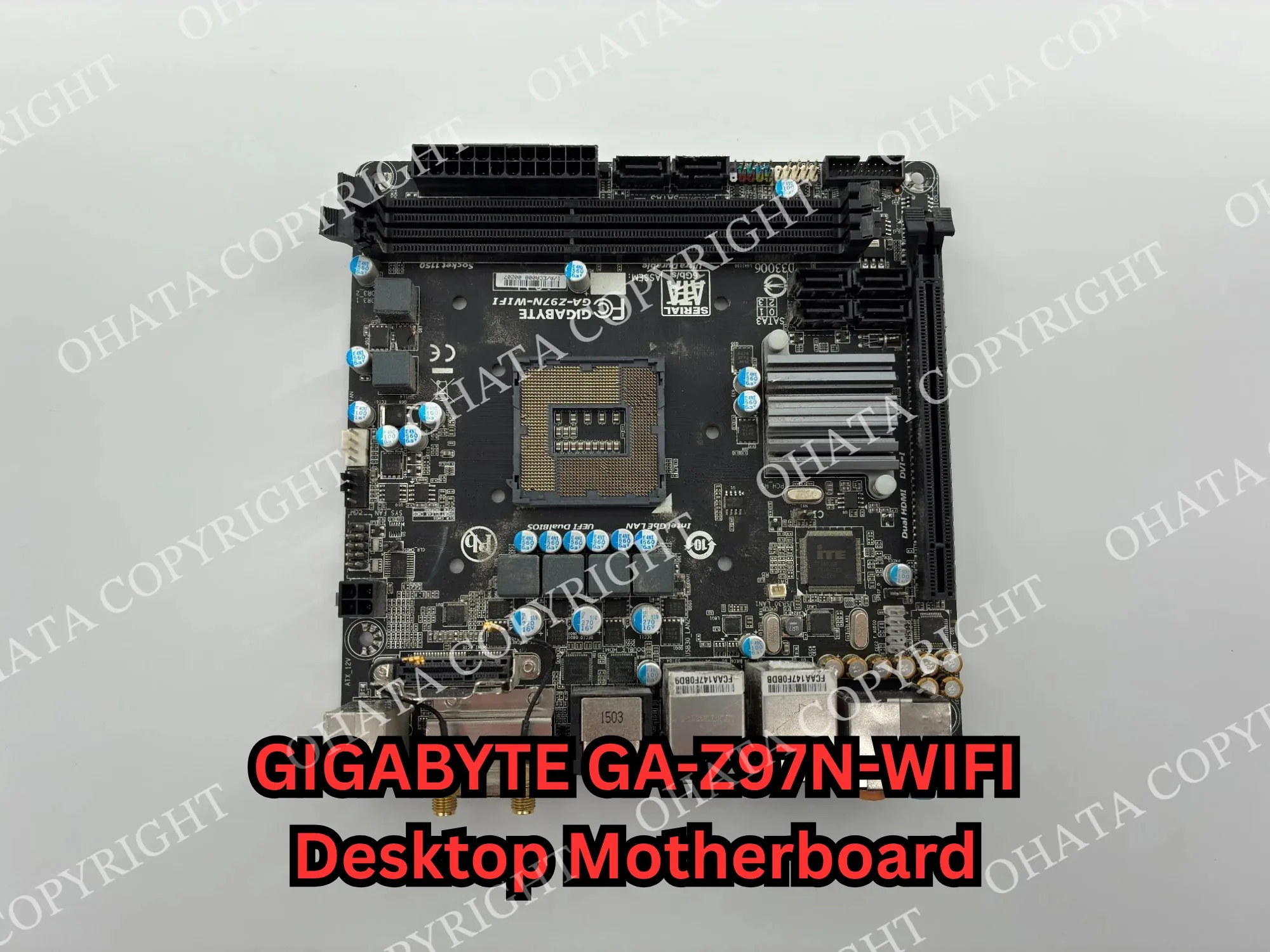 Front view of a compact GIGABYTE desktop motherboard with an empty CPU socket, memory slots, connectors, and attached heat sinks.