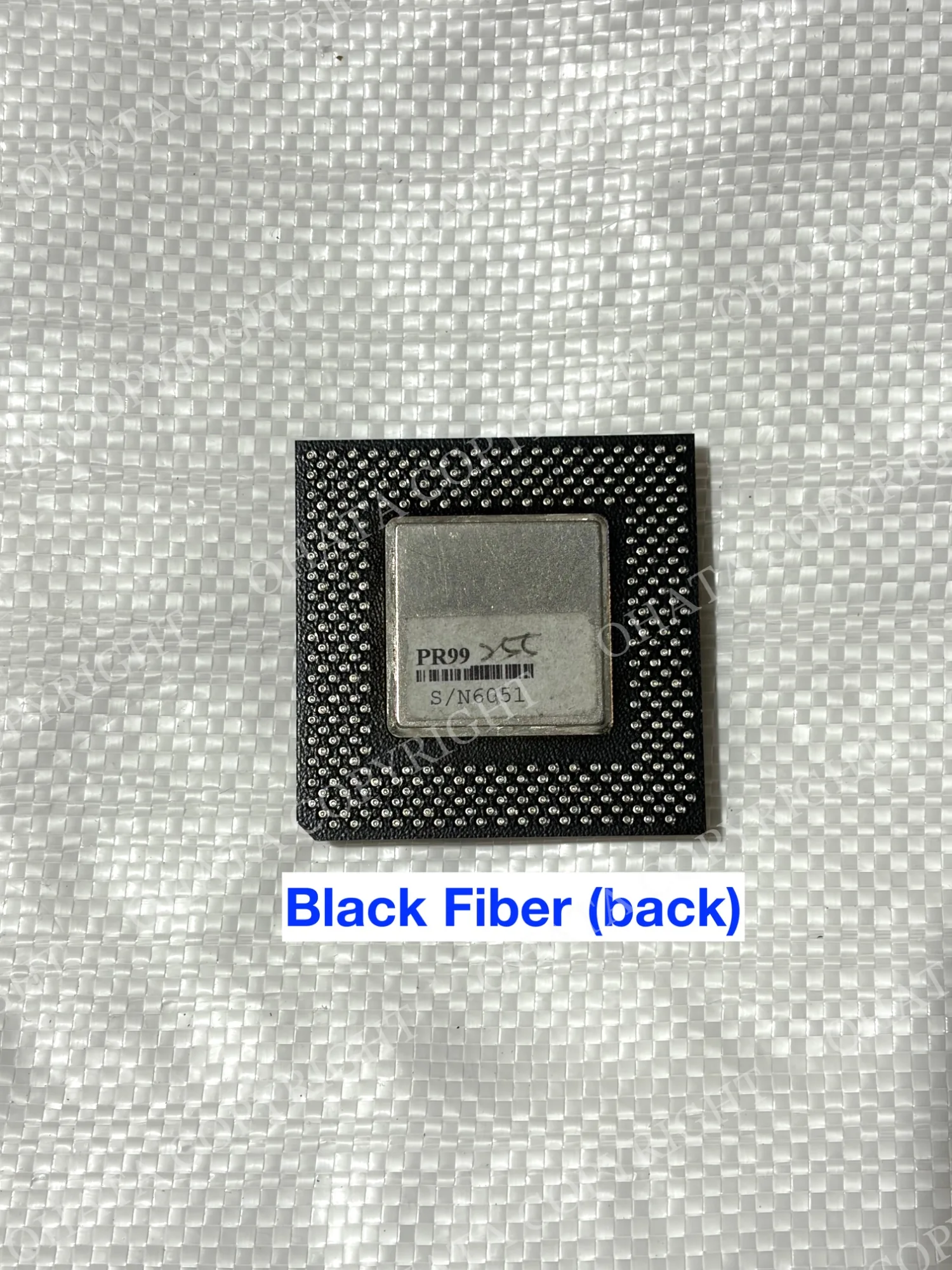 Opposite-side view of a black CPU package with a central metal plate.