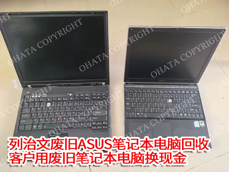 Two old, discarded laptops with their lids open