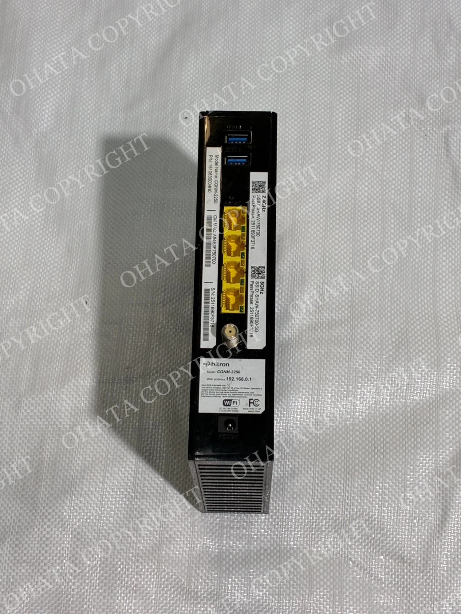 Rear of a black Hitron CGNM-2250 modem-router gateway showing USB ports, four Ethernet ports, coaxial input, power connection, and product labels.